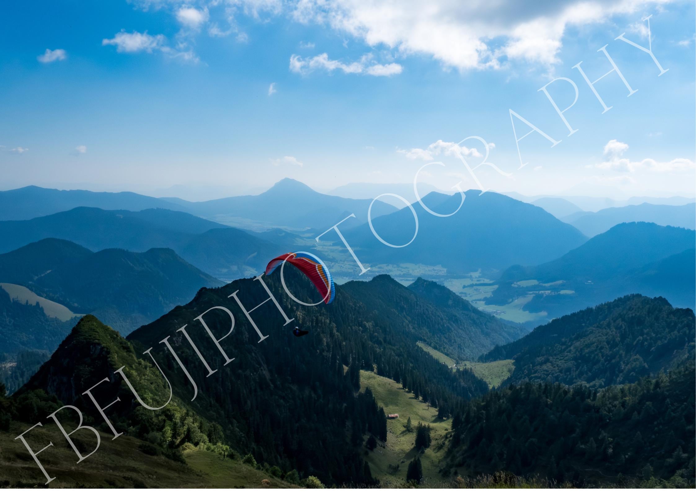 Gleitschirm über Berglandschaft | Paragliding Fotokunst in Blau & Grün | Panorama Wandbild mit Talblick