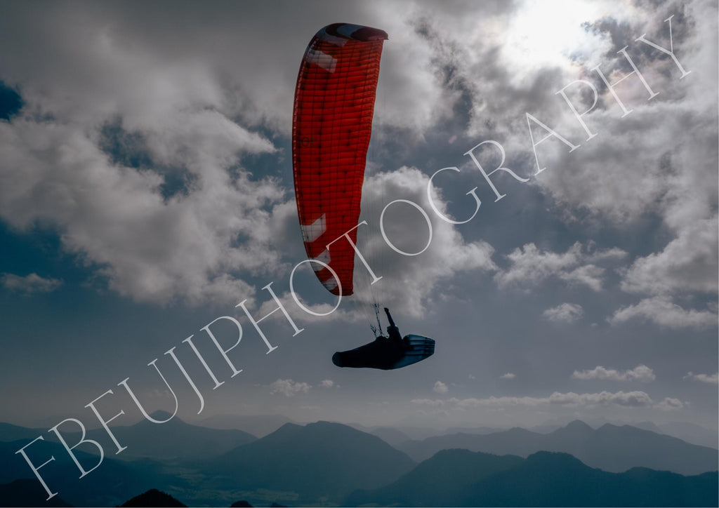 Paragliding mit rotem Schirm | Dramatischer Himmel & Berge | Gleitschirm Poster mit Wolken | Abenteuer Wandbild